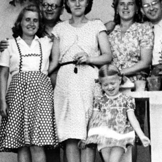 Family portrait on a porch with flower planters.