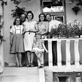 Family portrait on a porch with flower planters.