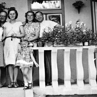 Family portrait on a porch with flower planters.