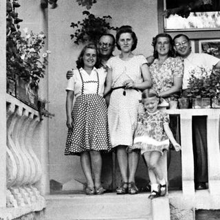 Family portrait on a porch with flower planters.