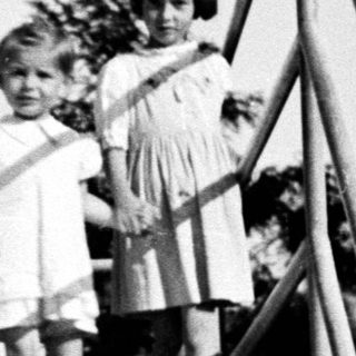 Three young girls stand on a set of concrete stairs.
