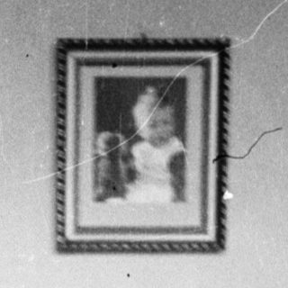 Young girl stands holding a doll and basket.