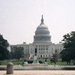 The United States Capitol Building is visible across a lawn.