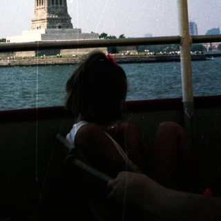 The Statue of Liberty is visible from a boat.