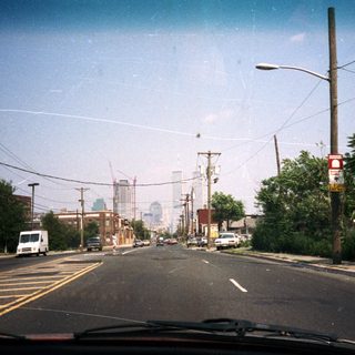 Street view with buildings and foliage in the distance.