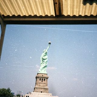The Statue of Liberty is seen through a structure.