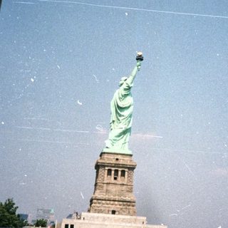 The Statue of Liberty is seen through a structure.