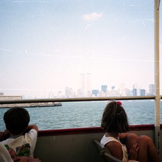 Statue of Liberty viewed from a boat, city skyline.