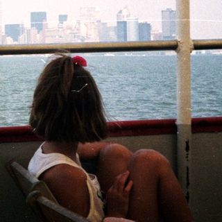 Statue of Liberty viewed from a boat, city skyline.