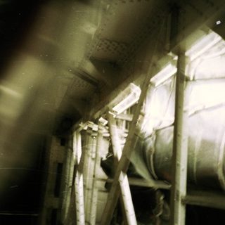 Industrial machinery and scaffolding in a dimly lit space.