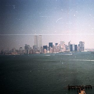 NYC skyline view across water, boats visible.