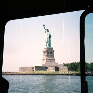 The Statue of Liberty is visible across the water.