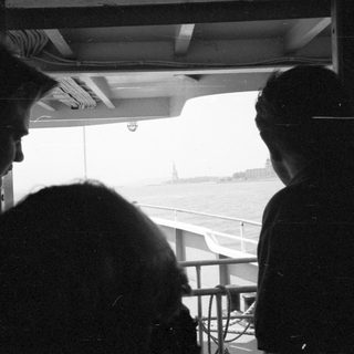 People looking at the Statue of Liberty from a boat.