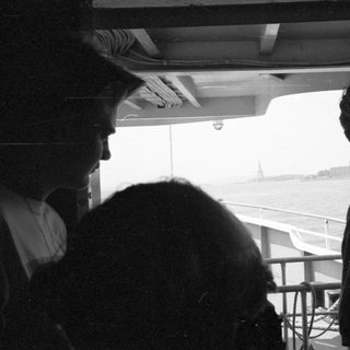 People looking at the Statue of Liberty from a boat.