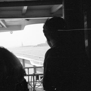 People looking at the Statue of Liberty from a boat.