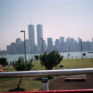 NYC skyline with the Twin Towers visible across water.