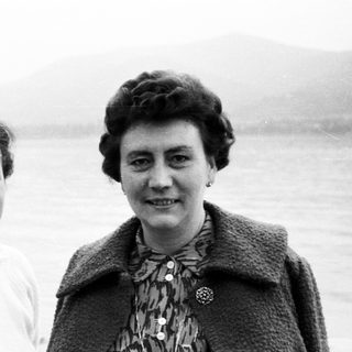 Two women posing outdoors, likely in a coastal area.