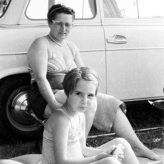 Black and white photo of a girl and woman near a car.