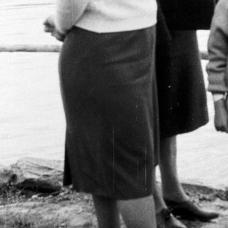 Pregnant woman, another woman, and a young girl by a lake.