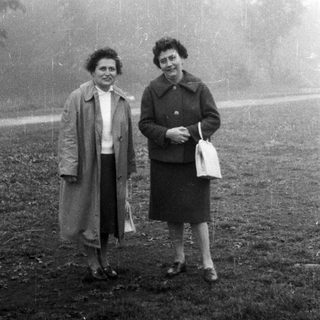 Two women stand outdoors in a black and white photo.