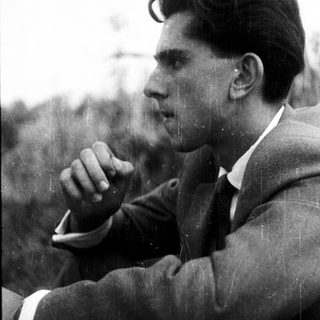 Man in suit looks pensive in side profile.