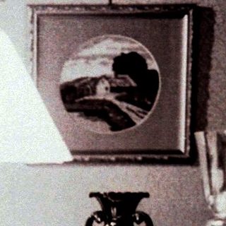Woman sits at a piano in a vintage-style room.
