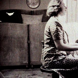 Woman seated at a piano in a vintage interior.