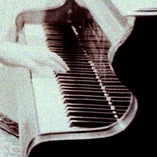 Woman playing piano in vintage patterned dress.