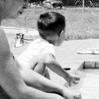 Family enjoying backyard pool on sunny day.