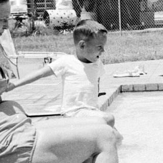 Children playing in a backyard pool.