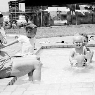 Children playing in a backyard pool.