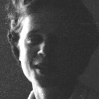 Young woman smiling indoors near window.