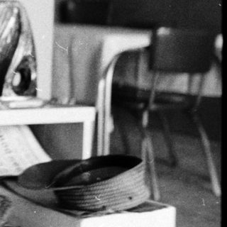 Man cutting hair of seated person indoors.
