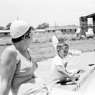A woman and child by a pool.