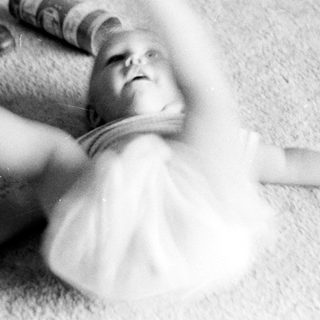 Baby being playfully lifted by an adult.