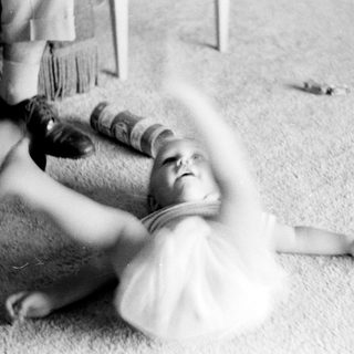Baby being playfully lifted by an adult.