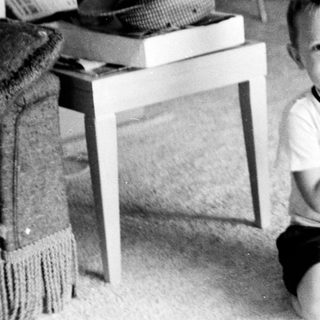 Young boy smiling indoors in playroom setting.