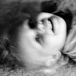 Child laughing while lying on floor.