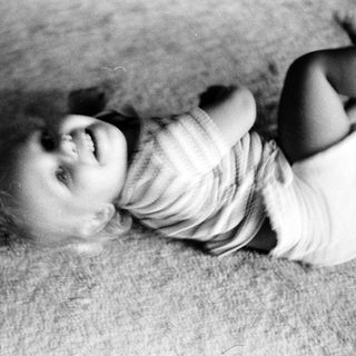 Child laughing while lying on floor.