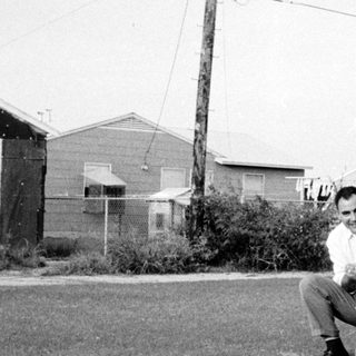 Man kneeling with young child outdoors.