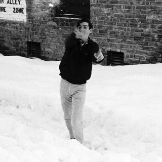 Snowy alleyway with man firing gun.