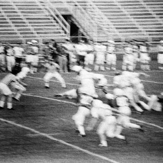 Group of runners in a stadium track race.