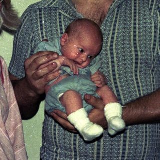 Family portrait with parents holding newborn baby.