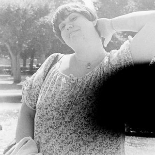 Person posing with arm stretched upward outdoors.