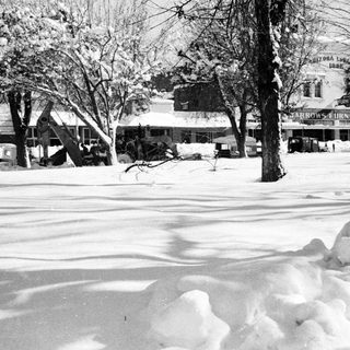 Snow-covered small town street with businesses.