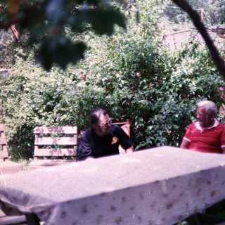 Two people sitting outdoors at a table.
