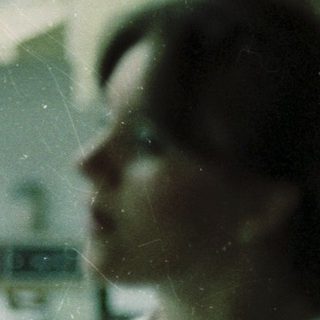 Blurred indoor kitchen scene with person wearing white shirt.