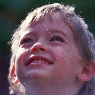 Joyful child laughing in sunlight.