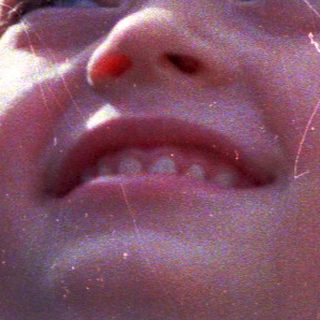 Joyful child laughing in sunlight.