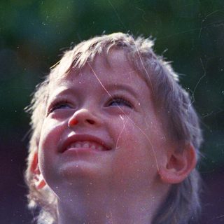 Joyful child laughing in sunlight.